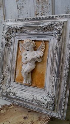 an old photo frame with a small angel on it