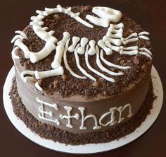 a chocolate cake with white frosting and skeleton decorations