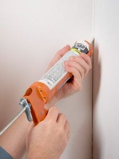 a man using a screwdriver to fix a wall