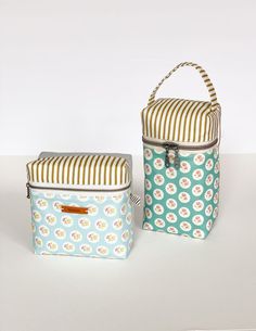 two lunch bags sitting next to each other on a white surface with stripes and flowers