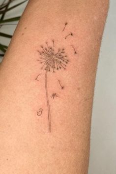 a small dandelion tattoo on the right thigh, with words written in cursive writing