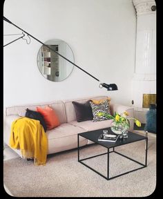 a living room with a couch, coffee table and mirror on the wall above it