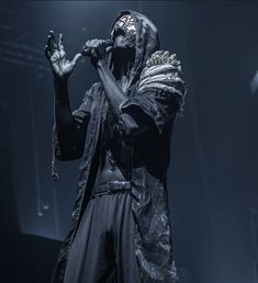 a man with his hands in the air while wearing a black outfit and headgear