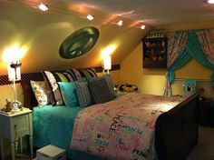 a bedroom with yellow walls and blue bedspread, lights on the headboard