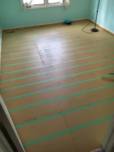 an empty room with wood flooring being painted in blue and green colors, next to a window