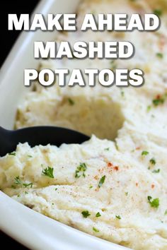 mashed potatoes in a white dish with a black spoon and text overlay that reads make ahead mashed potatoes