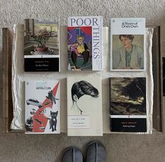 there are many books on the floor with one person's shoes next to them