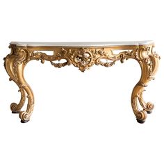 an ornate console table with marble top and gold leaf decorations on the legs, against a white background