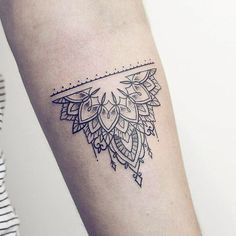 a woman's arm with a tattoo design on the left side of her arm