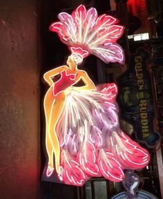 a neon sign that has a woman in a dress on it