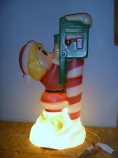 a lamp that is on top of a table with a cell phone in the shape of a santa clause