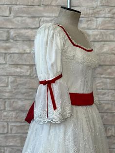 Professional ballet costume for the role of Macha (Clara) in the Nutcracker Act I. This stage costume has been designed by a famous tutu maker, for Dancewear by Patricia. The dress is made with white French Chantilly lace, and features a square neck with lace frills and deep red satin ribbons, three quarter sleeves and a wide deep red sash which ties in the back with a large bow. The mid calf length dress is entirely lined, with red satin ribbons towards the hem line, and customized to the dance Lace Victorian Dress With Historical Design For Costume, Victorian Lace Dress With Historical Design For Costume, Fitted Lace Victorian Dress For Costume Party, Fitted White Costume With Ruffles, White Fitted Costume With Ruffles, White Victorian Dress With Historical Design For Costume, White Victorian Dress With Fitted Bodice For Costume Party, White Historical Dress For Costume Party, White Ballet Dresses For Dance