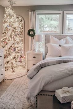 a bedroom decorated for christmas with white and silver decor