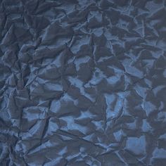 an up - close shot of the textured surface of a sheet of dark blue paper