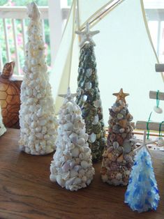 three small trees made out of seashells on a table