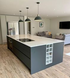 a large kitchen with an island in the middle and two pendant lights hanging from the ceiling