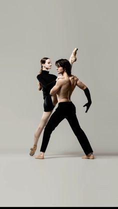 two dancers in black and white pose for the camera with their arms behind each other