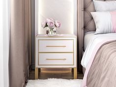 a white and gold nightstand next to a bed with pink flowers on top of it