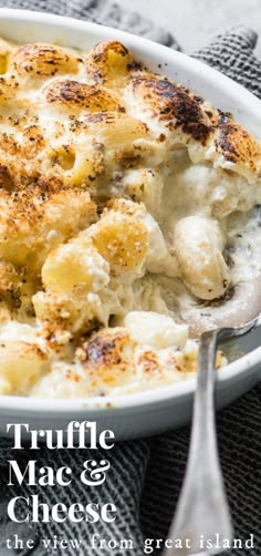 a white bowl filled with macaroni and cheese on top of a gray cloth