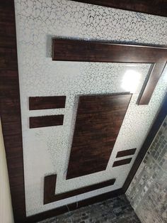 an overhead view of a bathroom with brown and white tiles on the walls, wood trimming around the shower