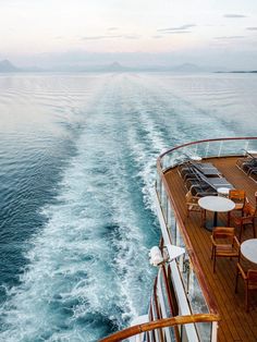 the back deck of a cruise ship with tables and chairs on it's side