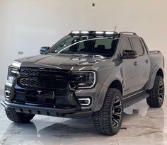 a silver truck parked in a white room with lights on it's headlamps