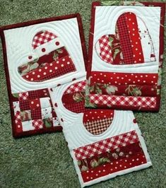 four red and white quilted placemats with hearts on them, sitting on the floor