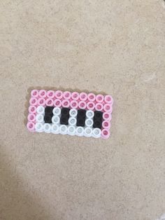 a pink and white beaded object sitting on top of a table