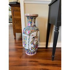 a vase sitting on the floor next to a table