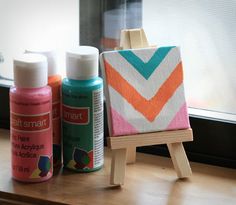 some crafting supplies are sitting on a window sill near a painting easel