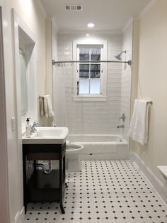 a white bathroom with black and white floor tiles on the walls, sink, toilet and bathtub