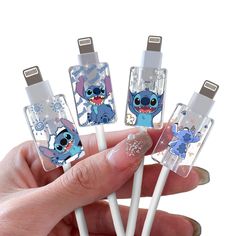 the person is holding four different type of usb devices in their hand, with cartoon characters on them