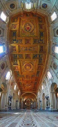 the inside of a large building with gold and blue decorations on it's ceiling