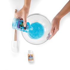 a person pouring blue liquid into a bowl with an ice cream scooper and toothbrush