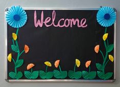 a welcome bulletin board with paper flowers on it