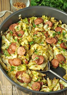 sausage and cabbage casserole in a skillet with a serving utensil