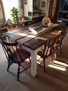 a wooden table with chairs around it in a room