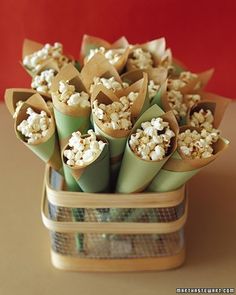 a bunch of food wrapped in paper on top of a wooden table next to a red wall