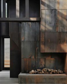 a fire place in the middle of a room next to a wall with metal panels on it