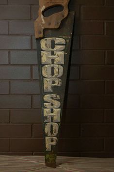 an old sign that says chop chop with a knife hanging from it's side