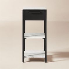 a black and white shelf with two shelves on each side, against a beige background