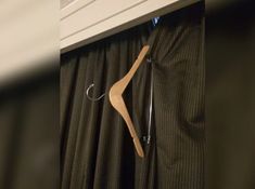 a wooden hanger on the side of a curtain