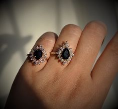 a woman's hand with two black and white diamond rings on top of it