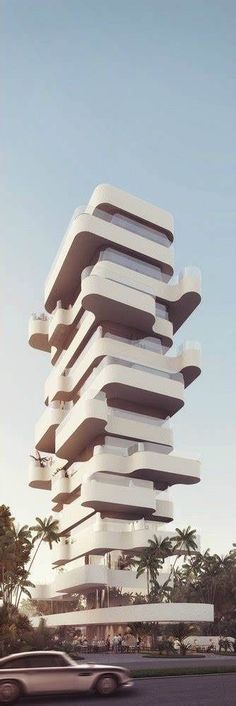 a very tall building with lots of balconies on it's sides in the middle of a street