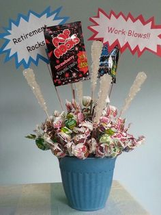 a blue pot filled with candy and candies on top of a table next to a sign