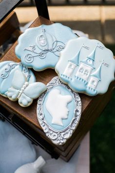 some cookies are sitting on top of a wooden box in the shape of houses and buildings