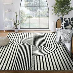 a black and white area rug in front of a large window with potted plants