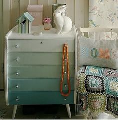 a white dresser sitting next to a wall with a letter b on it's side