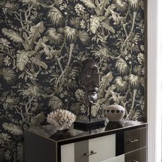 a black and white wallpaper with an intricate design on the sideboard in front of it