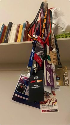 a book shelf filled with lots of books next to a pile of cards and medals